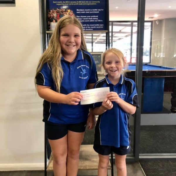 Two children holding a cheque at the club
