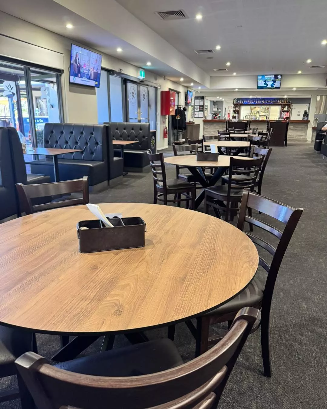 Indoor club dining area with tables, chairs, and bar
